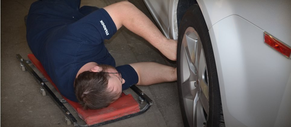 A technician working under a car